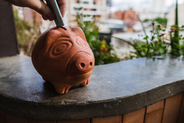 Sticker - Closeup shot of a person putting a banknote into a piggy bank