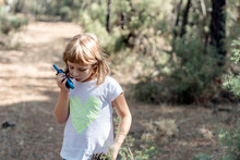 Girl Talking With A Two-way Radio In A Forest