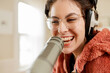 © Léa Jones/Stocksy - smiling young woman recording a podcast