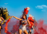 Samba girl on outdoors party with red smoke bomb 