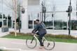 © Mihajlo Ckovric/Stocksy - Young african american businessman riding a bicycle to work in the urban city zone