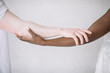 © Jovana Rikalo/Stocksy - Black woman and male albino holding hands close up