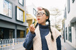 © Pansfun Images/Stocksy - Young Asian woman eating snacks