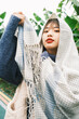 © Pansfun Images/Stocksy - Portrait of young fashionable Asian woman with two braids