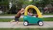 © Gabriel (Gabi) Bucataru/Stocksy - Caucasian boy pushing an African American boy in a toy car