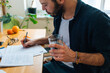 © Vertikala/Stocksy - Handsome young adult man writing at home office
