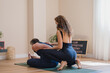 © Javier Pardina/Stocksy - Instructor teaching paschimottanasana yoga pose