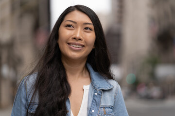 Wall Mural - Young Asian woman in city walking street smile happy face