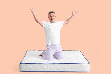 Sticker - Happy mature man on soft mattress against color background