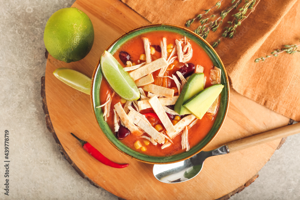 Bowl of tasty chicken enchilada soup on table