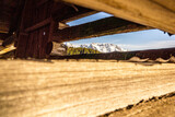 Fototapeta Sawanna - Mountain view through planks of a cabin
