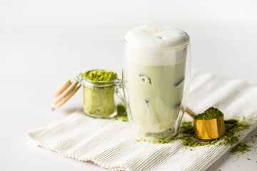 Matcha green tea latte with ice cubes on the white background