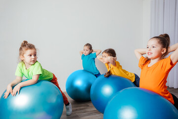 Wall Mural - Cute kids balancing laying on large fitballs