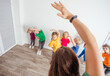 © oksix - Teacher engaging prescholers to do morning physical exercises