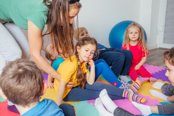 Teacher comforting upset girl after failure while doing physical exercise