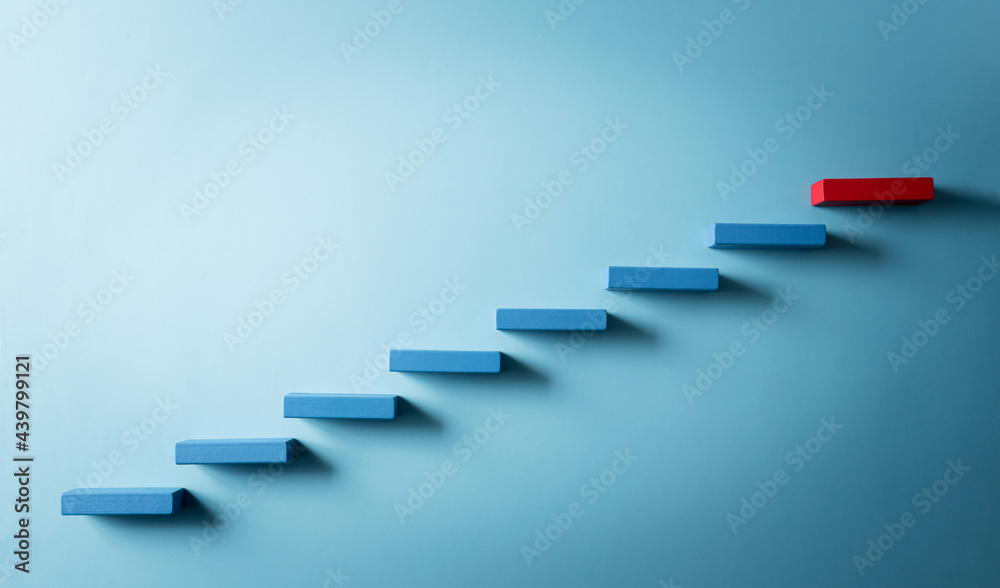 Concept of building success foundation. Yellow and red wooden block stacking as step stair, Success in business growth concept on pastel blue background. - obrazy, fototapety, plakaty 