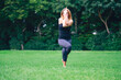 © Carlo Prearo - woman in park practicing yoga in nature on grass with barefoot