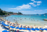 Fototapeta Uliczki - crowded beach on the Ligurian Sea, Lerici , Italy with blue umbrellas