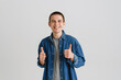 © Drobot Dean - Young brunette white man smiling and showing thumbs up