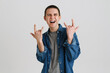 © Drobot Dean - Young brunette man smiling and gesturing horns sign