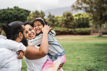Wall Mural - happy indian family having fun outdoor at city park - main focus on girl face