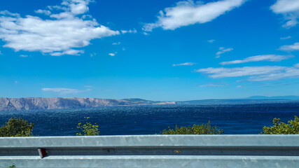 Wall Mural - View from road with guardrail and sea against blue sky in summer in Krk, Croatia