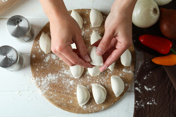 Concept of cooking vareniki or pierogi on white wooden table