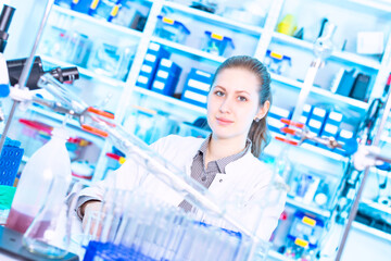 Canvas Print - Young female student at university chemistry laboratory smiling and posing at camera