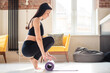 © WellStock - Young woman in sport clothes rolling out yoga mat