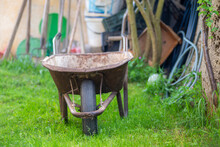 Selective Focus Shot Of An Old Rusty Wheelbarrow In The Garden