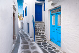 Fototapeta Na drzwi - Traditional greek house with blue door and staircase in narrow city alley. Mykonos Island, Greece.