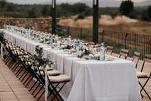 Outdoor Wedding Reception With White Bunting Flags And String Lights And View On Spanish Landscape
