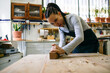© Inuk Studio/Stocksy - Female carpenter working with plane in workshop
