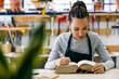 © Inuk Studio/Stocksy - Female carpenter reading book in workshop