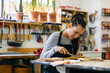 © Inuk Studio/Stocksy - Craftswoman working with antique carved object