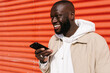 © Ezequiel Giménez/Stocksy - Black man sending voice messages by mobile on the street
