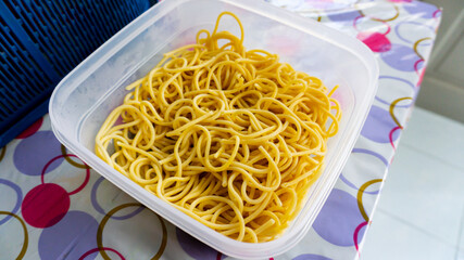 Close up view of pasta noodles or Spaghetti in a food container after being boils on a table.