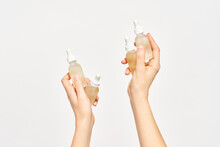 Set Of Bottles With Cosmetic Oil In Hands Of Woman