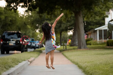 Little Girl Playing With Bubbles On A Neighborhood Sidewalk