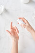 © Martí Sans/Stocksy - Hands with moisturizing cream sample.