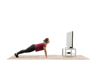 Sticker - Young woman doing plank exercise in front of a tv