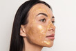 © Anna Tabakova/Stocksy - Woman with gold gel facial mask