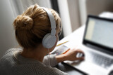 Fototapeta  - blonde woman with headphones working on notebook computer