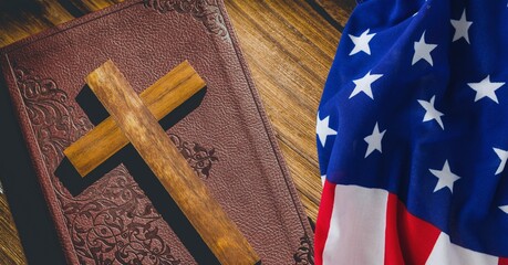 Canvas Print - American flag over wooden cross over bible against wooden background