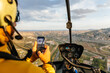 © Marcos Osorio/Stocksy - Helicopter passenger taking photos with his mobile