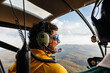 © Marcos Osorio/Stocksy - Passenger and pilot of a helicopter flying over the mountains