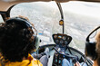 © Marcos Osorio/Stocksy - Passenger and pilot of a helicopter flying over the city