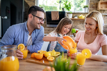 Poster - Family make fresh orange juice in their kitchen