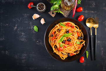 Wall Mural - Spaghetti alla puttanesca - italian pasta dish with tomatoes, black olives, capers, anchovies and basil. Top view, flat lay