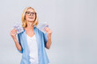© denis_vermenko - Happy winner! Image of a mature senior happy old woman standing isolated over a white wall background, looking at the camera holding money.